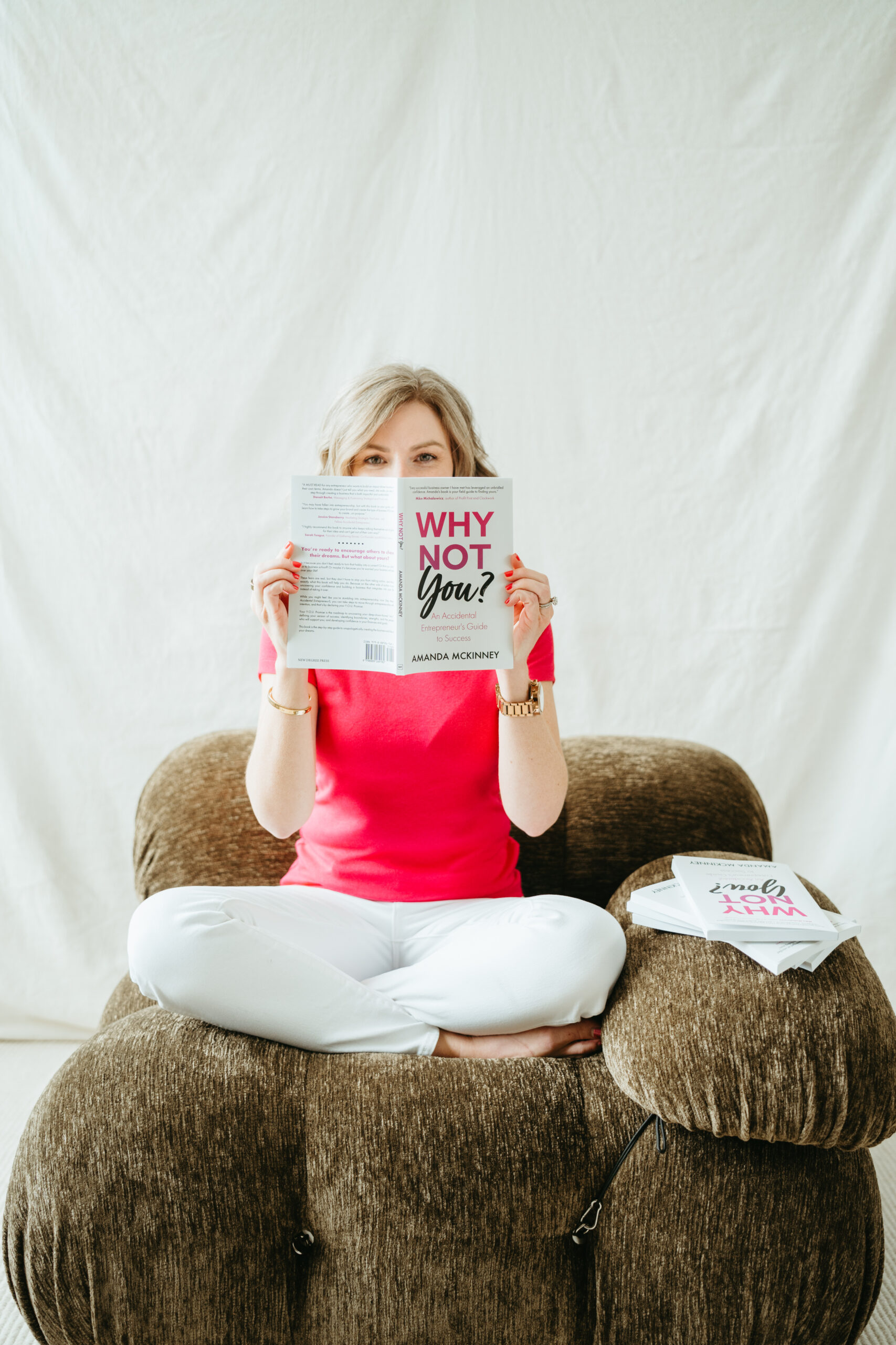 Amanda holding her book sitting in a chair