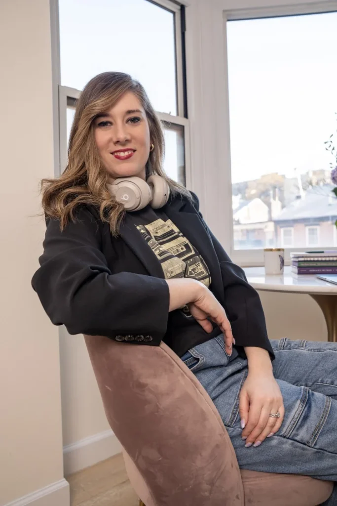 Janet sitting in a chair with a window behind her